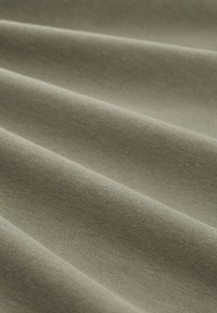 Olijfgroen stof met een gladde textuur, met subtiele plooien en een zachte glans. Gemaakt van een niet-gespecificeerd textielmateriaal.