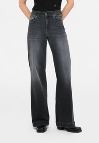 Wijde, donkergrijze denim jeans met een hoge tailleband, frontzakken en een subtiele vervaging. De stiksels zijn zichtbaar langs de naden en zoom.