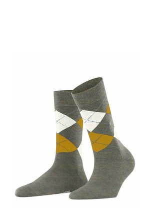 Calze grigie con un motivo argyle a rombi di colore giallo, bianco e blu chiaro, posizionate in verticale su uno sfondo bianco.