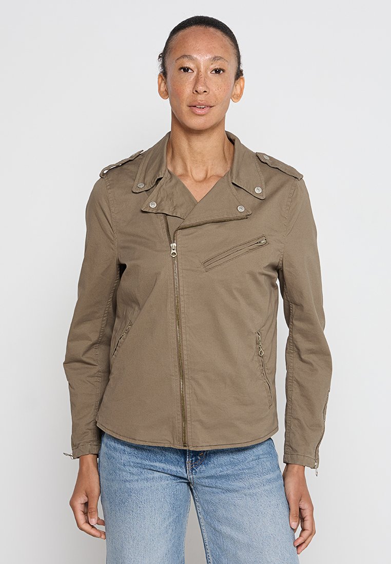 Veste légère marron avec une fermeture éclair diagonale, un col à bouton-pression et deux poches avant. Coutures apparentes et épaules structurées.