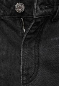 Čierna denimová tkanina s viditeľným zipsom a kovovým gombíkom v páse. Obsahuje jemné štruktúrované tkanivo a kontrastné švíky pozdĺž okrajov.