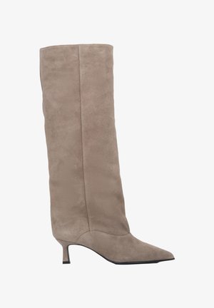 Beżowy surowy botek do kolan z wąskim noskiem, smukłą sylwetką i krótkim obcasem w kształcie szpilki. Gładka faktura z bezszwowym wykończeniem.