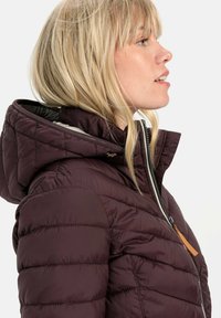 Burgunderfarbene Pufferjacke mit einem Reißverschluss vorne, hohem Kragen und abnehmbarem Kapuzen. Sie verfügt über gesteppte Abschnitte und ein Lederakzent.