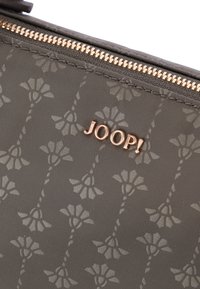 Sivka tekstilna torbica z cvetličnim vzorcem, rožnato zlato okovje in izstopajočim embosiranim logotipom z napisom "JOOP!" ob zadrgi.