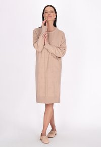 Vestito a maglia beige con polsini e orlo a coste, dotato di una tasca e un sottile motivo testurizzato su tutta la superficie. Tessuto morbido, design fino al ginocchio.