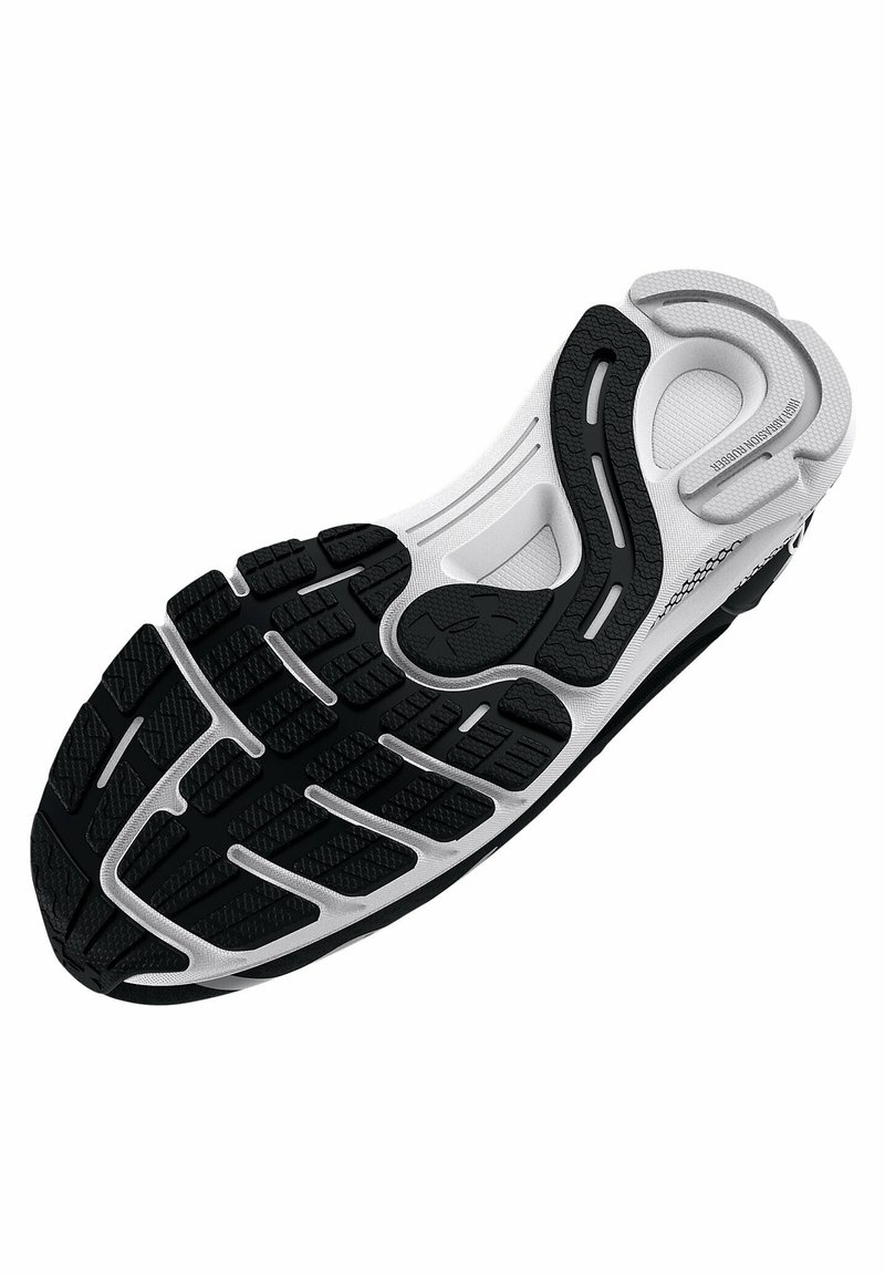 Semelle d'une chaussure de sport noir et blanc avec des motifs de grip texturés et des détails de rembourrage pour la course ou l'entraînement.
