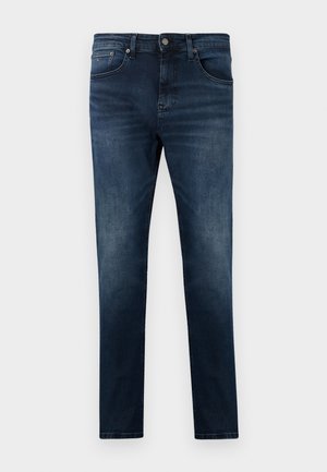Jeans de ganga azul escuro com um corte ajustado, apresentando um design de perna reta, cinco bolsos e detalhes em metal prateado. Textura de tecido desbotado.