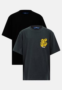 Två kortärmade t-shirts: en svart, en mörkgrå med gula leendes handavtryck. Tillverkade av bomull, med rund hals och avslappnad passform.
