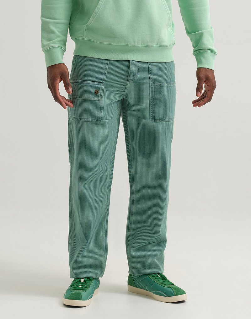 Mint green corduroy cargo pants with vertical stripes; features pockets at the sides; paired with matching green sneakers and a hoodie.