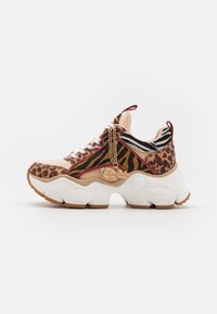 Sneaker épais avec un design mixte de motifs animaliers featuring des motifs de léopard et de tigre. Semelle blanche avec des détails en matériel doré et des accents rouges.