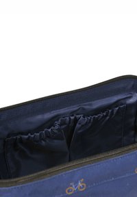 Navy blue tasinterieur met een gladde textuur, met elastische compartimenten voor organisatie en een decoratief fiets patroon aan de buitenkant.