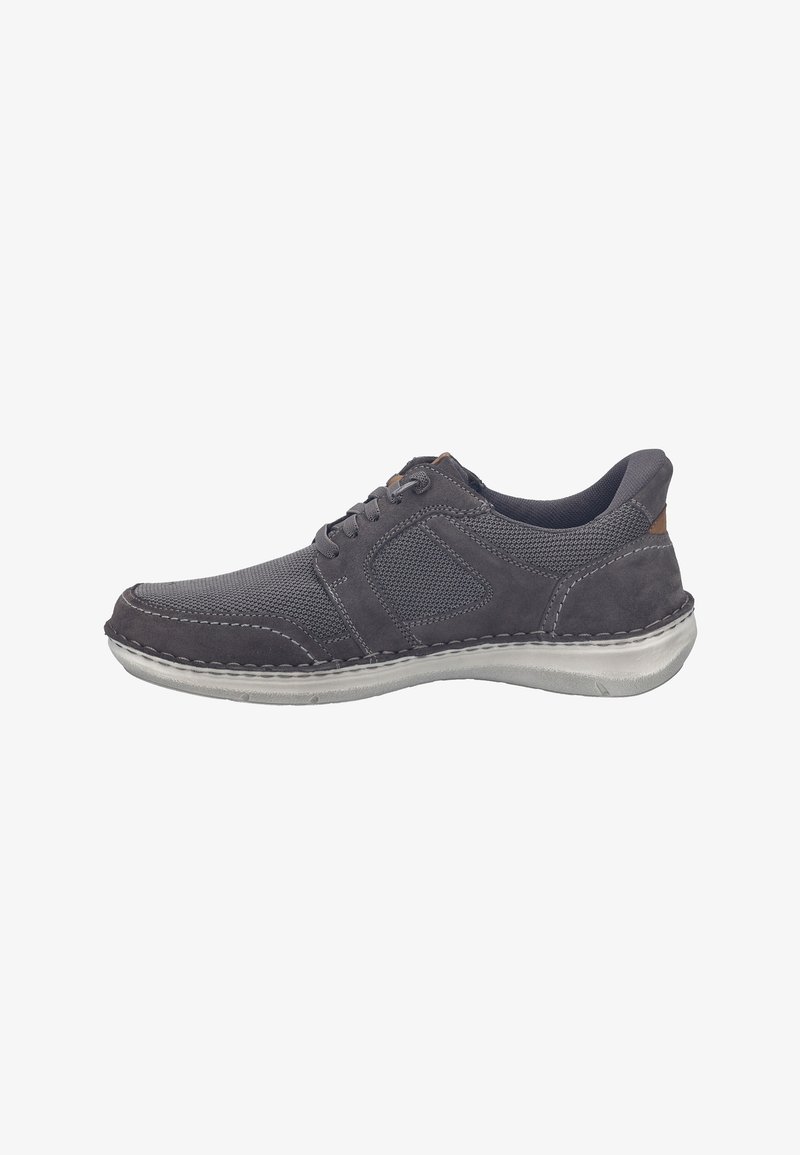 Zapatilla deportiva gris oscuro con materiales de malla y ante, diseño con cordones, punta redondeada, costuras contrastantes y suela de goma flexible.