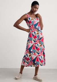 Robe midi sans manches avec un motif géométrique dans des tons rouges, bleus et bruns ; fabriquée en tissu léger avec une coupe décontractée.