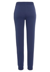 Marineblauwe joggingbroek met een taps toelopende pijp, elastische tailleband en geribbelde manchetten. Gemaakt van een zachte, rekbare stof zonder zichtbare zakken.
