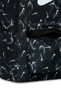 Sac à dos noir avec un motif répété de logo Nike blanc, en tissu texturé, doté d'une poche zippée à l'avant et de fermetures éclair noires robustes.