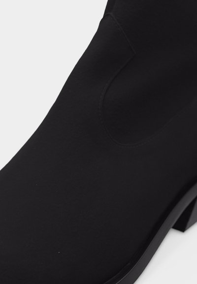 Black ankle boot with smooth matte finish, rounded toe, and block heel, shown from side angle on white background.