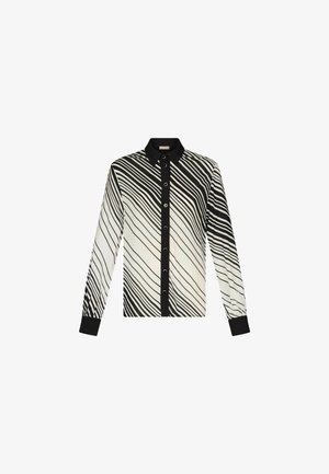 Maglietta a maniche lunghe a righe bianche e nere con colletto, chiusura a bottoni sul davanti e polsini neri. Tessuto dalla texture liscia.