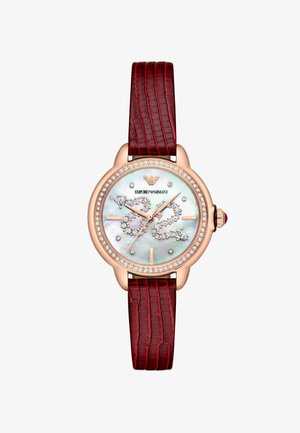 Montre en or rose avec un cadran rond en nacre, ornée de cristaux, et un bracelet en cuir rouge texturé avec un motif crocodile.