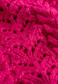 Forró rózsaszín kötött szövet texturált mintával, amely csavart öltéses részleteket és változó magasságokat tartalmaz, háromdimenziós megjelenést kölcsönözve.