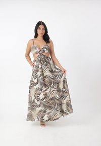 Maxikleid aus cremefarbenem Stoff mit braunen Palmenblättern, mit einem Schlüssel-Ausschnitt an der Brust und Spaghettiträgern. Glatte Textur.