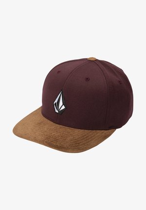 Baseballpet met een bruine suède klep en een donker bordeauxrode kroon met een zwart-wit geometrisch logo op het voorpaneel.