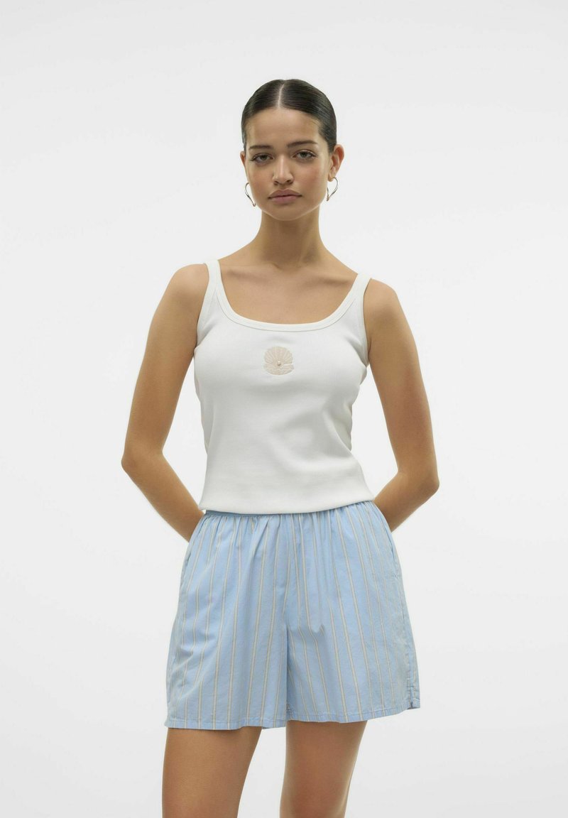 Witte geribde tanktop met een schelpenborduursel in het midden, gecombineerd met lichtblauwe gestreepte shorts met een elastische tailleband.