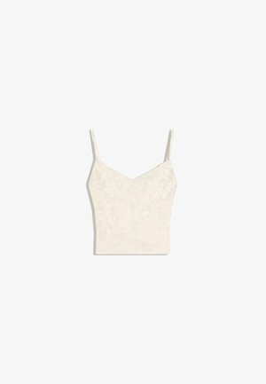 Cream-colored cropped camisole with thin straps and subtle floral pattern on a light background.