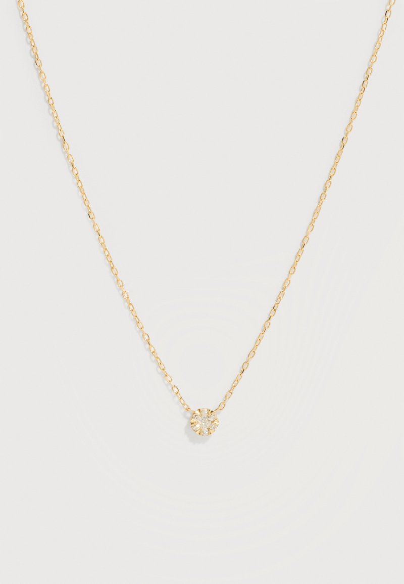 Λεπτό χρυσό κολιέ αλυσίδας με κεντρικό μονο πετράδι, στρογγυλό και διαφανές, σε ένα απλό ανοιχτό φόντο.