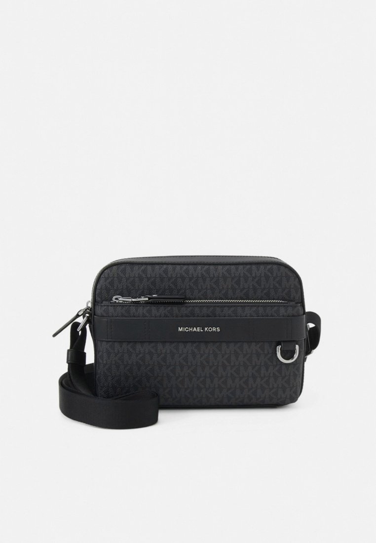 Sac bandoulière en tissu noir avec un motif de logo texturé, une poche avant zippée, des accents en cuir et une sangle réglable. Détails de la ferrure en argent.