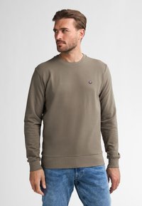 Felpa a maniche lunghe verde oliva scuro con colletto a girocollo e polsini a costine. Presenta un piccolo logo ricamato sul petto. Tessuto morbido.
