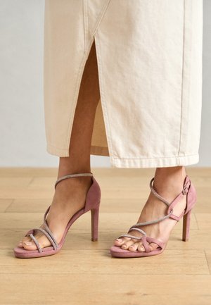 Rosa mockakängor med hög klack, med korsade remmar och silverdetaljer, som har en öppen tå-design och strukturerad yta.