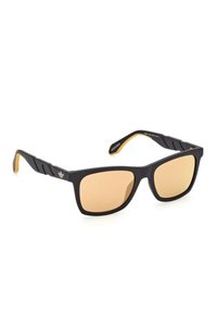 Occhiali da sole neri a forma rettangolare con lenti marroni, dotati di una montatura nera texture e accenti gialli sulle astine. Dettaglio del logo presente.