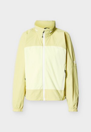 Φωτεινό κίτρινο μπουφάν με φερμουάρ έως το λαιμό, ψηλό γιακά, ελαστικά μανίκια, δύο πλαϊνές τσέπες με φερμουάρ και αντίθετη ανοιχτόχρωμη μπροστινή επιφάνεια.