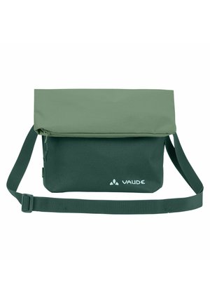 Bolso de hombro verde con solapa plegable, correa ajustable y logo de Vaude en la esquina inferior derecha del frente.