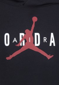 Felpa nera con cappuccio caratterizzata da una grande silhouette rossa di un giocatore di basket in volo con una palla e testo bianco che recita "OARIDRA".