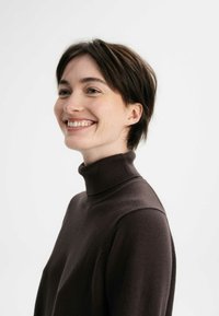 Brauner Rollkragenpullover aus einem weichen, strukturierten Stoff, mit einem taillierten Ausschnitt und einer lässigen Silhouette. Einfache Gestaltung ohne auffällige Muster.