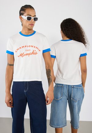 White short-sleeve t-shirts with blue ringer accents. Front features "Championship 1988 Memphis" in orange. Styled with denim shorts.