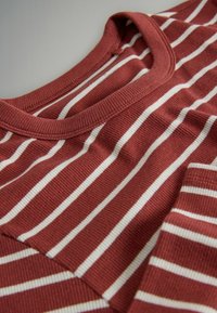 Rdeča in bela bombažna majica z rebrasto teksturo in okroglim izrezom, z prekrivajočo se tkanino na področju ramen.