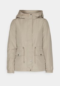 Beige hettejakke med glidelås foran, snøring i midjen og to frontlommer. Har elastiske mansjetter og en glatt, vannavstøtende tekstur.