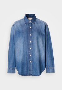 Camicia in denim con bottoni, di colore azzurro chiaro, maniche lunghe, colletto classico, bottoni frontali e orlo leggermente curvo. Tessuto morbido.