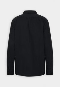 Chemise noire à manches longues avec col classique, poignets boutonnés et une texture de tissu lisse. Aucune motif ou embellissement visible.
