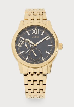 Zlatá kovová náramková hodinky s čiernym ciferníkom, rímsky číslica XII, dve subciferníky na dátum a 24-hodinový čas a zlatý článkový náramok.