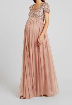 Długa, zwiewna sukienka wykonana z miękkiej, prześwitującej tkaniny w odcieniu różu brzoskwiniowego. Posiada dopasowany gorset ozdobiony cekinami oraz krótkie rękawy.