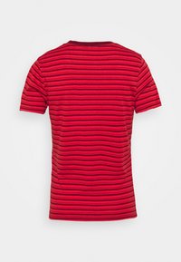 Camiseta de manga corta roja a rayas con rayas horizontales de diferentes anchos. Tejido suave con escote redondeado y sin logotipos visibles.