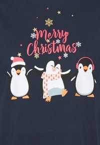 Tre glada pingviner med julhatt, scarf och öronmuffar under texten "God Jul" med gyllene och vita snöflingor och stjärnor.