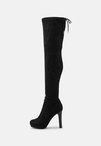 Botas altas de ante negro hasta la rodilla, con punta afilada, tacón alto y parte superior fruncida con cordón. Se ajustan cómodamente a la pierna con una textura suave.