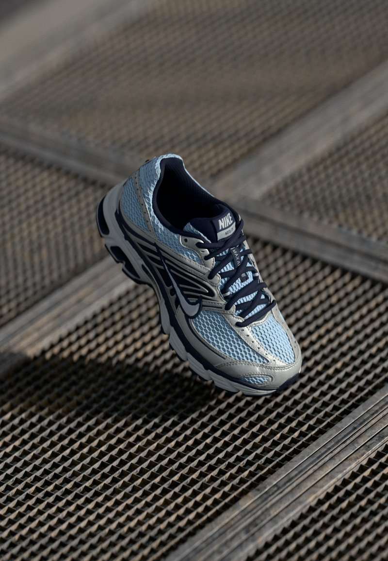 Sapatilha de corrida Nike em azul claro e marinho. Parte superior em malha, sola intermédia acolchoada, detalhes em preto contrastante e sola em borracha com padrão de tração.