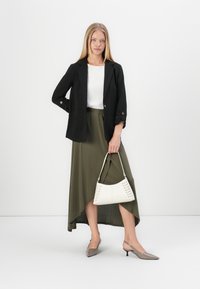 Zwarte blazer, witte top, olijfgroene asymmetrische rok. Grijze slingback hakken. Witte handtas met vetersluiting. Gladde texturen, modern ontwerp.