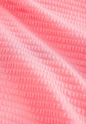 Tkanina jarke ružičaste boje s naglašenim vodoravnim reljefnim linijama i suptilnim sjajem, stvarajući valoviti izgled preko površine.