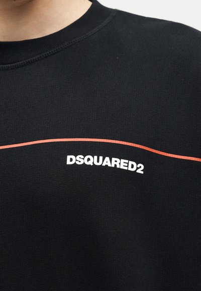 Zwart shirt met een ronde hals en een dunne horizontale rode lijn boven het witte "DSQUARED2"-logo op de borst.